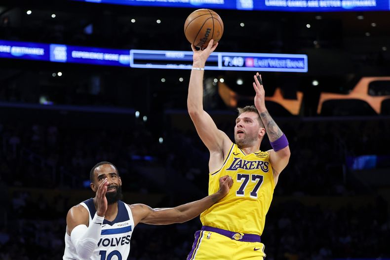 El base de los Lakers de Los Ángeles Luka Doncic lanza el balón frente a Mike Conley de los Timberwolves de Minnesota en el encuentro del viernes 24 de octubre del 2025. (AP Foto/Jessie Alcheh)