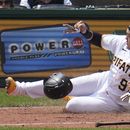 Ji Man Choi de los Piratas de Pittsburgh anota la segunda de dos carreras con el sencillo de Jared Triolo en la séptima entrada frente al relevista de los Guardianes de Cleveland el dominicano Enyel De Los Santos el miércoles 19 de julio del 2023. (AP Foto/Gene J. Puskar)