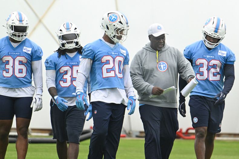 Randy Jordan, entrenador de corredores, platica con Tony Pollard (20) y Nick Singleton (32), en un grupo que completan Julius Chestnut (36) y Michael Carter (35), de los Titans de Tennessee, durante un entrenamiento del equipo de la NFL, el viernes 29 de mayo de 2026, en Nashville, Tennessee. (AP Foto/John Amis)