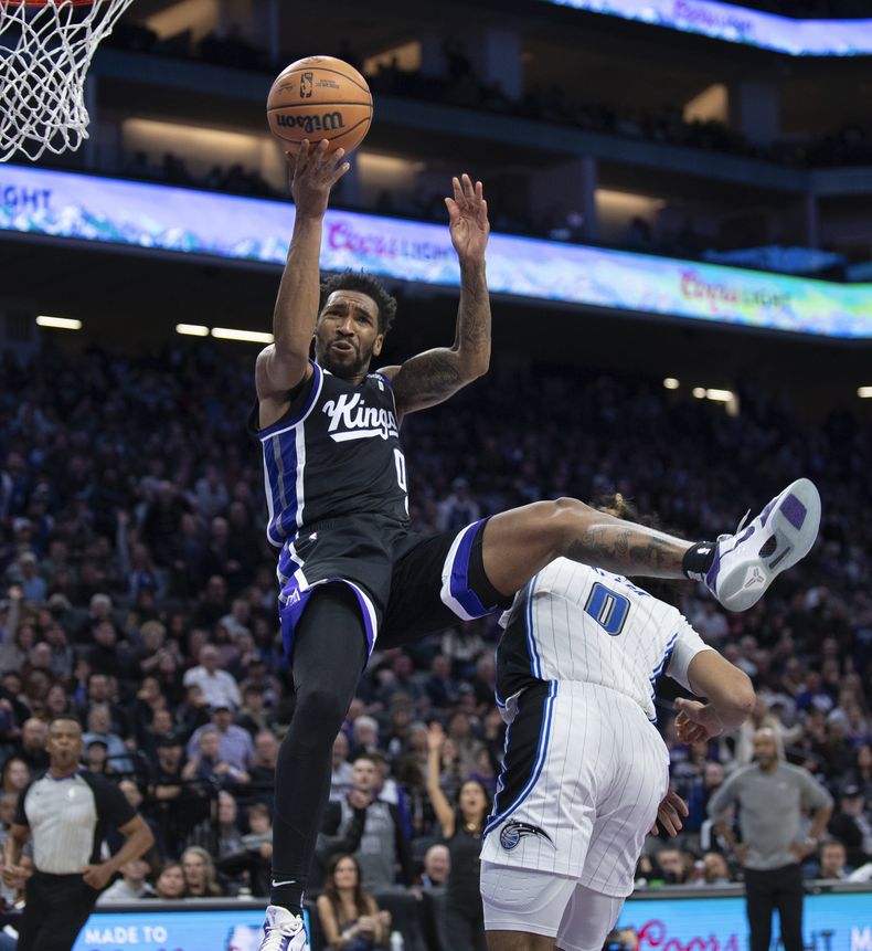 Malik Monk, de los Kings de Sacramento, recibe una falta de Anthony Black, del Magic de Orlando, durante el partido del miércoles 3 de enero de 2024 (AP Foto/José Luis Villegas)
