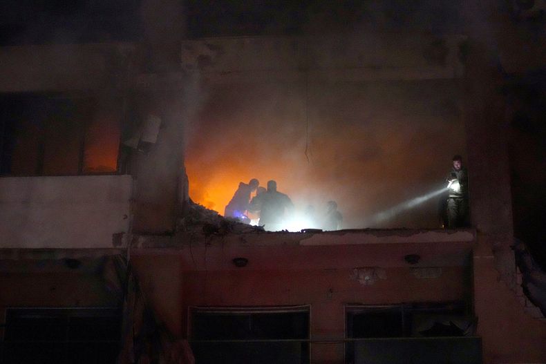 Varias personas buscan sobrevivientes dentro de un apartamento luego de una explosión en el suburbio de Dahiyeh, en el sur de Beirut, Líbano, el martes 2 de enero de 2024. (AP Foto/Bilal Hussein)