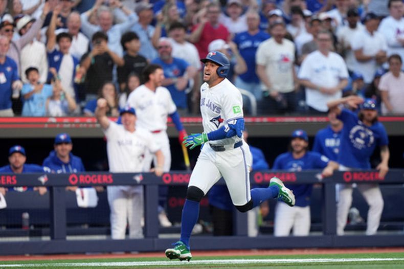 George Springer, bateador designado de los Azulejos de Toronto, corre hacia el plato después de pegar un triple y completar un jonrón de campo gracias a un error de fildeo de A.J. Ewing, de los Mets de Nueva York, durante la novena entrada del juego de béisbol de Grandes Ligas, el lunes 29 de junio de 2026, en Toronto. (Nathan Denette/The Canadian Press via AP)