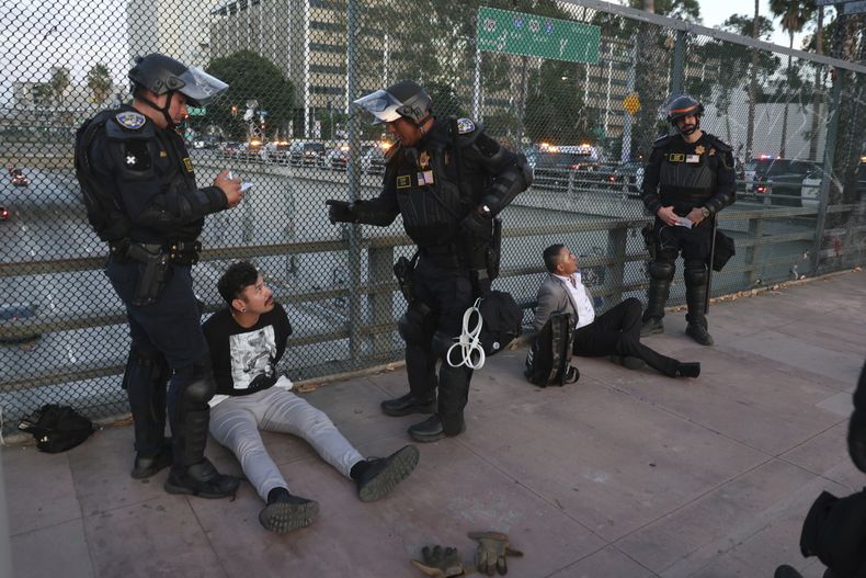 Policías arrestan a dos hombres en medio de protestas en Los Ángeles el 14 de junio del 2025. (AP foto/Ethan Swope)