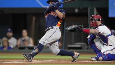 Houston Astros Jose Altuve, left, follows through on a solo home run as Texas Rangers Jonah Heim looks on in the first inning of a baseball game, Tuesday, Sept. 5, 2023, in Arlington, Texas. (AP Photo/Tony Gutierrez)