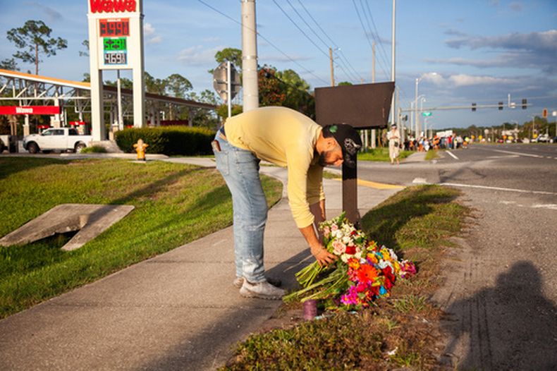 Edgar Olalde, de Jacksonville, que conocía a la víctima gracias a su tienda, deposita un ramo de flores durante una vigilia en honor de un mexicano que murió atropellado por un tráiler el día anterior mientras huía de un encuentro con agentes del Servicio de Inmigración y Control de Aduanas (ICE, por sus siglas en inglés), el miércoles 15 de julio de 2026, en St. Augustine, Florida. (AP Foto/Kelly Jordan)