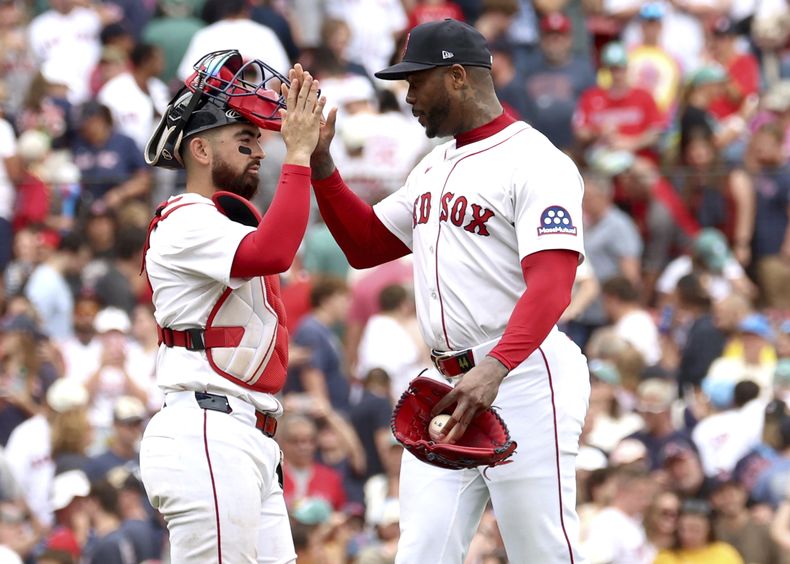 El cátcher de los Medias Rojas de Boston Connor Wong le da los cinco al pitcher Aroldis Chapman en el encuentro ante los Guardianes de Cleveland el lunes primero de septiembre del 2025. (AP Foto/Mark Stockwell)