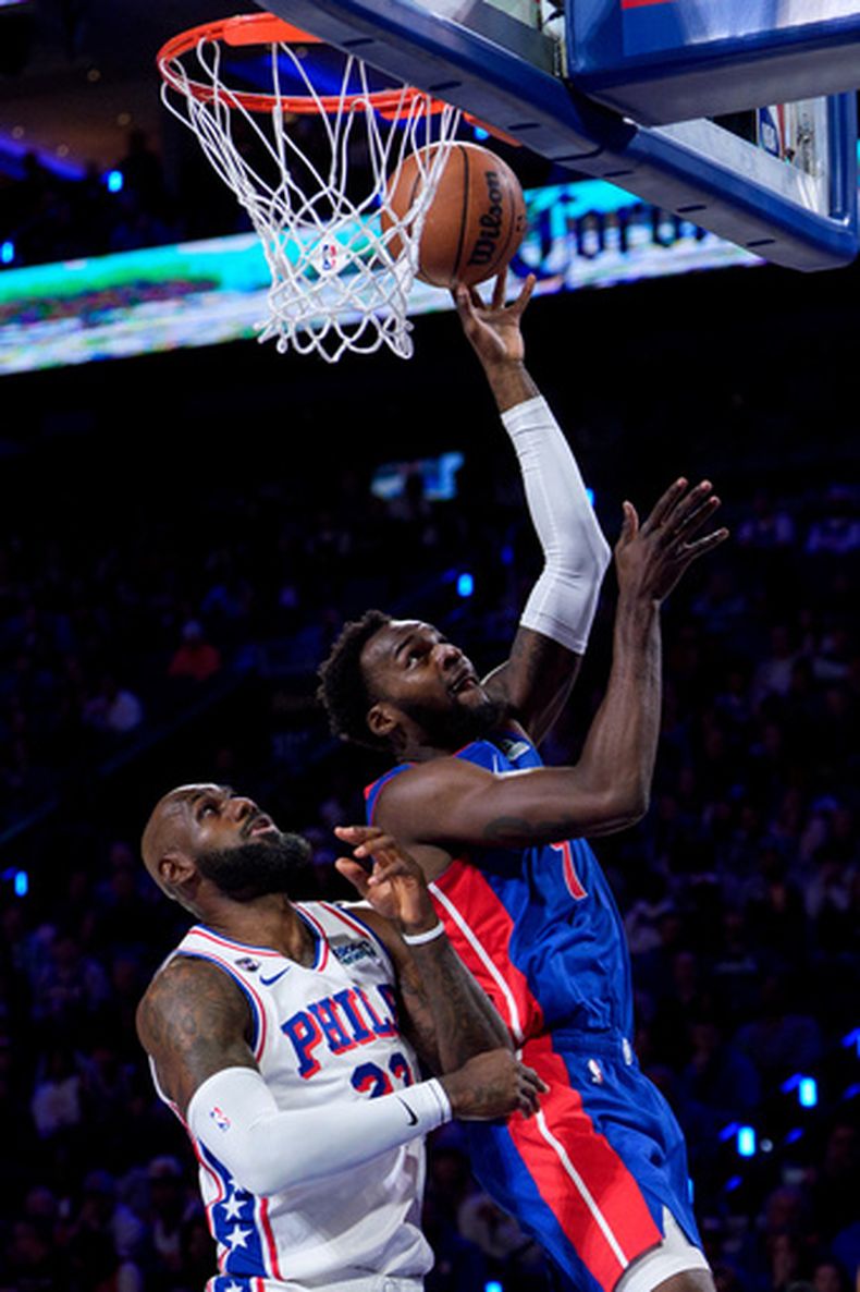 Paul Reed, derecha, de los Pistons de Detroit, encesta bajo la presión defensiva de LeBron James, izquierda, de los Sixers de Filadelfia, durante la primera mitad del juego de baloncesto de la NBA, el domingo 25 de octubre de 2926, en Filadelfia. (AP Foto/Chris Szagola)