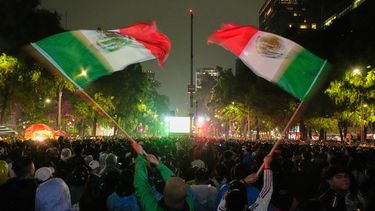 Aficionados mexicanos ondean banderas mientras observan el partido de dieciseisavos de final del Mundial entre México y Ecuador cerca del monumento al Ángel de la Independencia en la Ciudad de México, el martes 30 de junio de 2026. (AP Foto/Marco Ugarte)