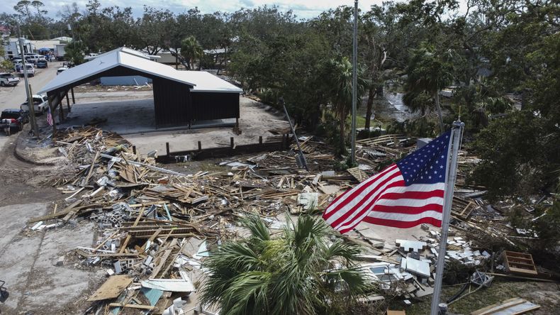 Una bandera estadounidense ondea sobre el Ayuntamiento destrozado el sábado 28 de septiembre de 2024 en Horseshoe Beach, Florida, tras el paso del huracán Helene. (AP Foto/Stephen Smith)
