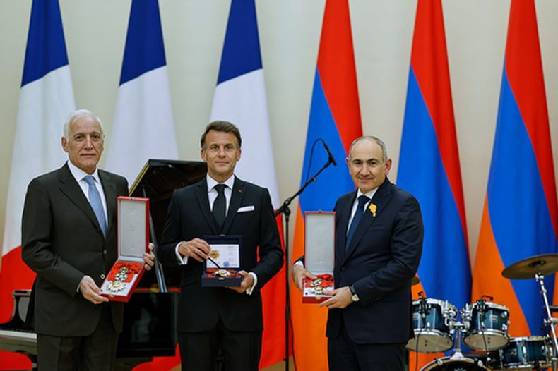 En la imagen, distribuida por la Oficina de Prensa del primer ministro, el presidente armenio Vahagn Khachaturyan, izquierda, el presidente francés Emmanuel Macron, centro, y el primer ministro armenio Nikol Pashinyan sostienen premios después de una cena de Estado tras la reunión de la Comunidad Política Europea en Ereván, Armenia, el lunes 4 de mayo de 2026. (Tigran Mehrabyan/ Oficina de Prensa del primer ministro de Armenia, vía AP)