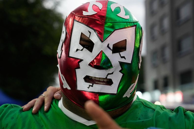 Un fanático de la lucha, con una máscara roja, verde y blanca, antes de entrar al México Arena, en la Ciudad de México, el 26 de junio de 2026. (AP Foto/Marco Ugarte)