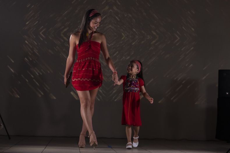 Modelos lucen prendas durante un desfile de modas con textiles guatemaltecos, el viernes 12 de mayo de 2023, en Brownsville, Texas. La diseñadora Elena de León, nacida en Guatemala, combinó técnicas indígenas de tejido, diseño moderno de ropa y colorida historia de su país natal en esa exhibición, la cual ofreció una muestra no sólo de su visión artística, sino un trabajo de madres guatemaltecas, incluidas algunas que viven en Estados Unidos y otras que se quedaron en su país para apoyar a sus familias. (AP Foto/Julio Cortez)