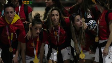 La lateral española Olga Carmona posa con sus compañeras tras la llegada del equipo al aeropuerto internacional Madrid-Barajas, el lunes 21 de agosto de 2023. (AP Foto/Paul White)