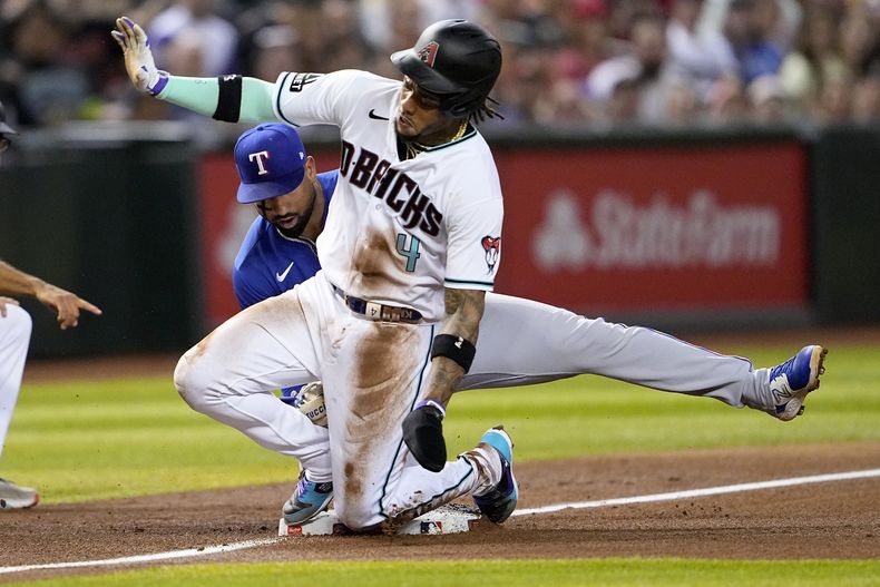 Ketel Marte (4), de los Diamondbacks de Arizona, avanza a tercera base en un elevado de Tommy Pham durante el cuarto inning del juego de la MLB que enfrentó a su equipo con los Rangers de Texas, el 21 de agosto de 2023, en Phoenix. (AP Foto/Matt York)