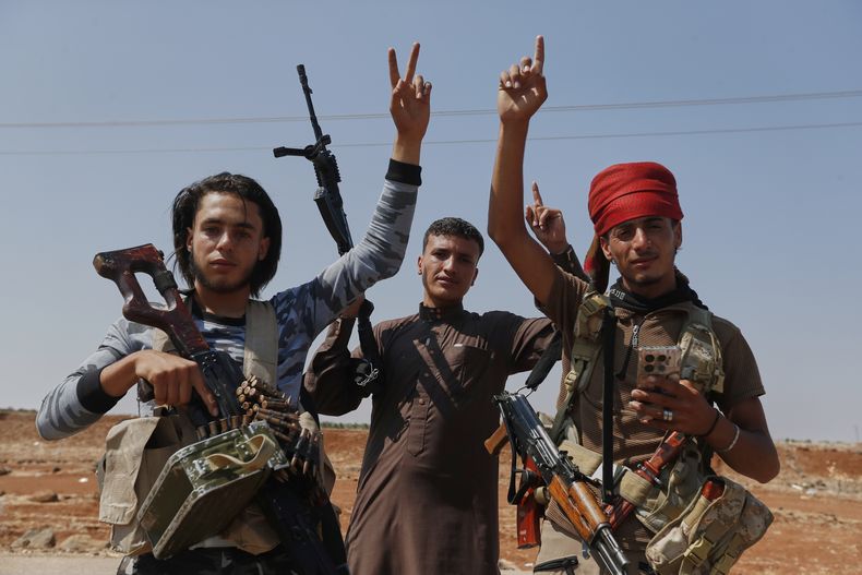 Combatientes beduinos se reúnen en el poblado de Busra al-Harir, en el noroeste de la ciudad de Sweida, mientras las fuerzas de seguridad acordonan el área, en el sur de Siria, el martes 22 de julio de 2025. (AP Foto/Omar Sanadiki)
