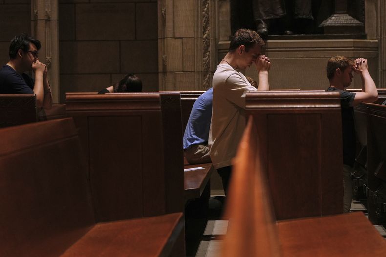 Eric Anderson, en el centro, ministro asociado del campus de la Universidad de Princeton, reza con otros, después de una misa el viernes 16 de mayo de 2025. (AP Foto/Luis Andrés Henao)