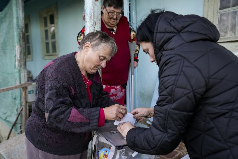 Una mujer emite su voto en una casilla móvil durante una segunda vuelta de las elecciones presidenciales, en la aldea de Ciopleni, Moldavia, el domingo 3 de noviembre de 2024. (AP Foto/Vadim Ghirda)