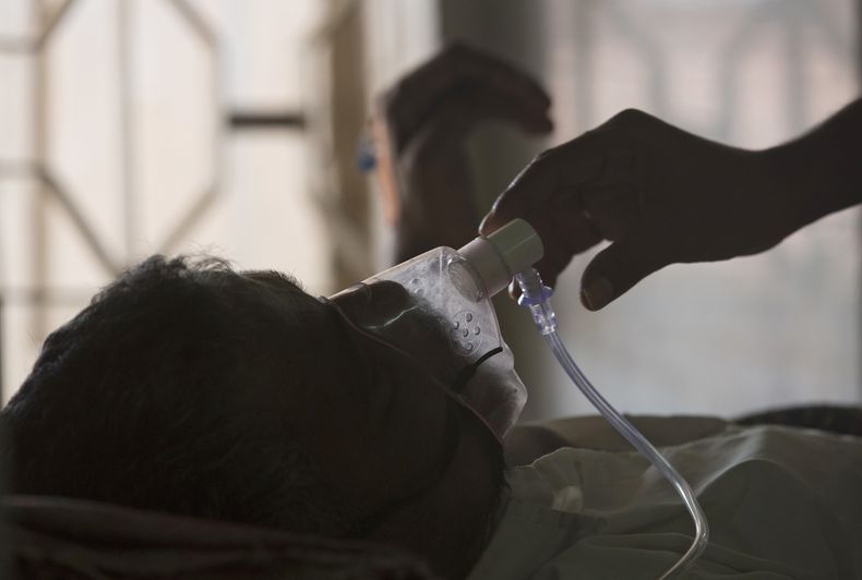 ARCHIVO - Un familiar ajusta la máscara de oxígeno de un paciente de tuberculosis en un hospital especializado en el Día Mundial de la Tuberculosis en Hyderabad, India, el 24 de marzo de 2018. (AP Foto/Mahesh Kumar A., Archivo)