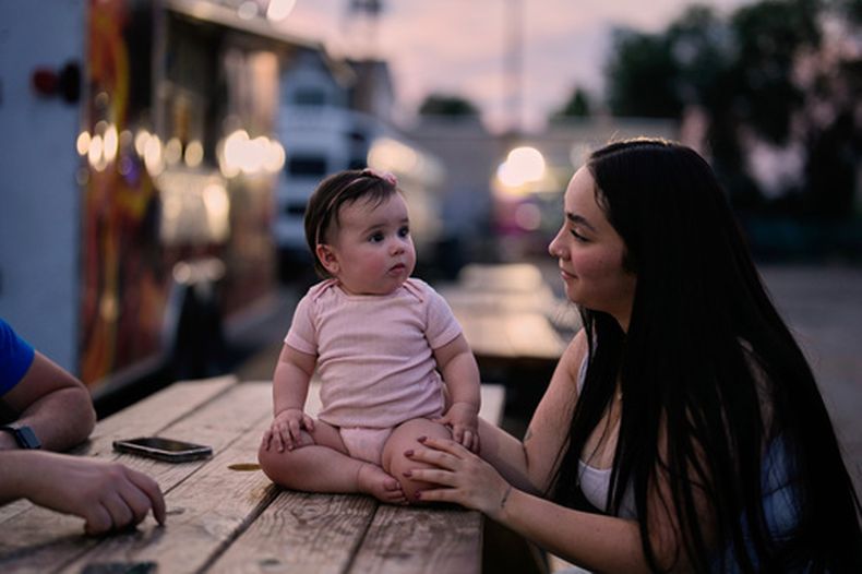 Una madre venezolana observa a su hija entre camiones de comida, el martes 14 de julio de 2026, en Midvale, Utah. (AP Foto/Gregory Bull)