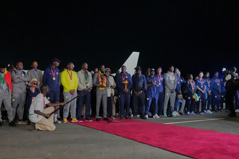 El presidente de Senegal, Bassirou Diomaye Faye (séptimo desde la izquierda) recibe a la selección de Senegal que se consagró campeona de la Copa Africana de Naciones al regresar al país el martes 20 de enero de 2026. (AP Foto/Misper Apawu)