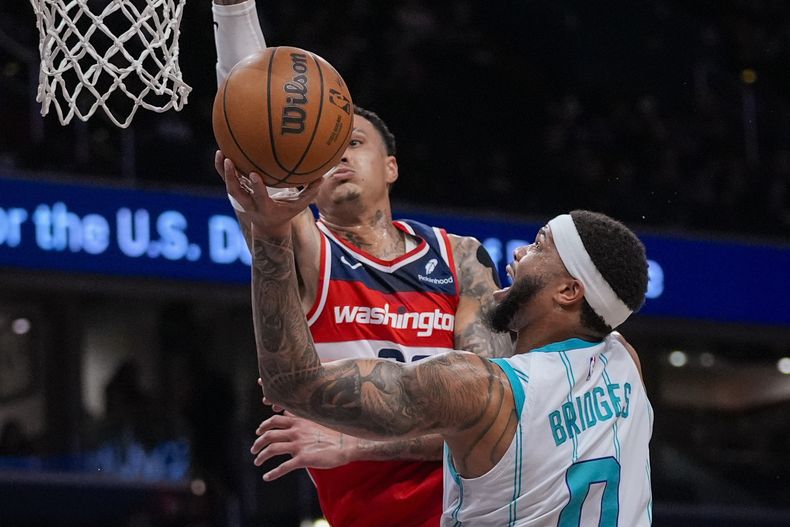 El alero de los Wizards de Washington Kyle Kuzma intenta bloquear un tiro del alero de los Hornets de Charlotte Miles Bridges (0) durante la primera mitad del juego de baloncesto de la NBA, el viernes 8 de marzo de 2024, en Washington. (AP Foto/Alex Brandon)