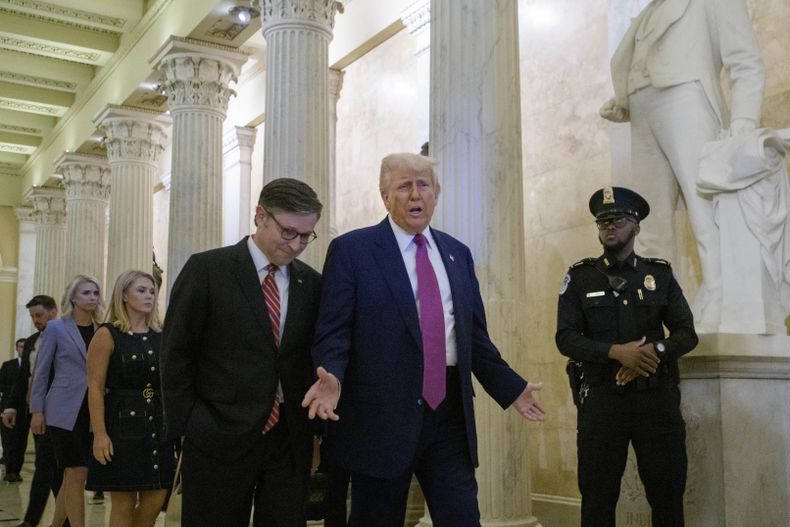 El presidente estadounidense Donald Trump, centro, y el presidente de la Cámara de Representantes, Mike Johnson, salen del Capitolio de Washington luego de una reunión con legisladores republicanos el martes 20 de mayo de 2025. (AP Foto/Rod Lamkey, Jr.)