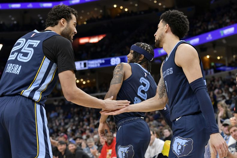 El brasileño Maozinha Pereira (izquierda) y Zavier Simpson, de los Grizzlies de Memphis, festejan en el partido del viernes 5 de abril de 2024, ante los Pistons de Detroit (AP foto/Brandon Dill)