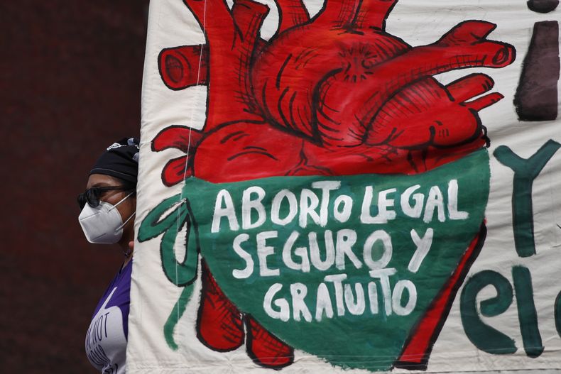 ARCHIVO – Una mujer lleva una pancarta a favor del aborto mientras manifestantes protestan frente al Congreso Nacional en el Día de la Despenalización del Aborto en América Latina y el Caribe, en Ciudad de México, el 28 de septiembre de 2020. El aborto está despenalizado en 12 de los 32 estados y una resolución de la Suprema Corte allanó el camino para que lo esté en todo el territorio. Pero la presidenta ha evitado profundizar sobre este tema durante la campaña. (AP Foto/Rebecca Blackwell, Archivo)