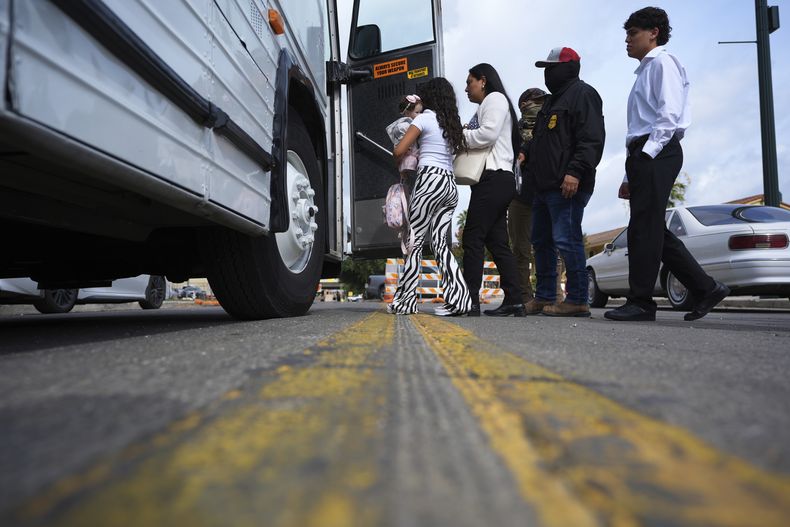 Una familia procedente de Colombia es detenida y escoltada a un autobús por agentes federales luego de una audiencia en un tribunal de inmigración, el lunes 14 de julio de 2025, en San Antonio. (AP Foto/Eric Gay)