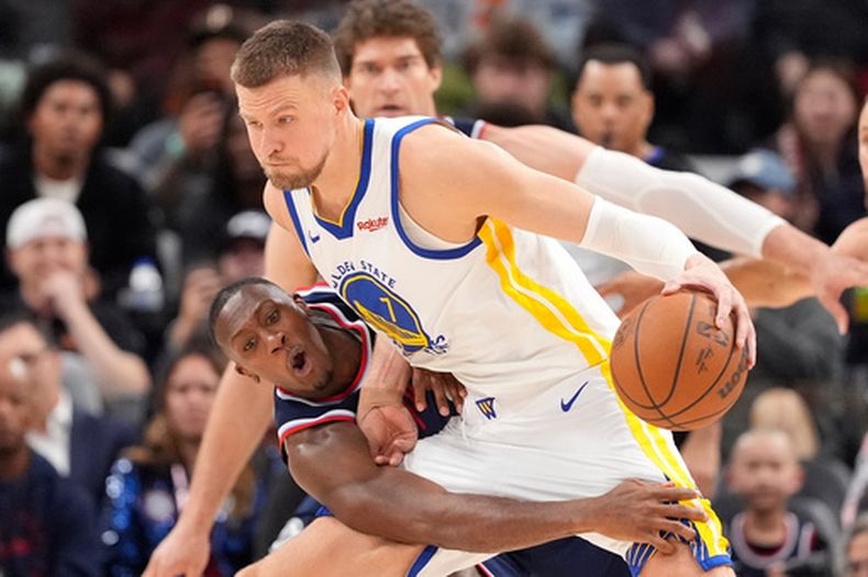 El base de los Clippers de Los Ángeles intenta alcanzar el balón de Kristaps Porzingis de los Warriors de Golden State en el encuentro del miércoles 15 de abril del 2026. (AP Foto/Mark J. Terrill)