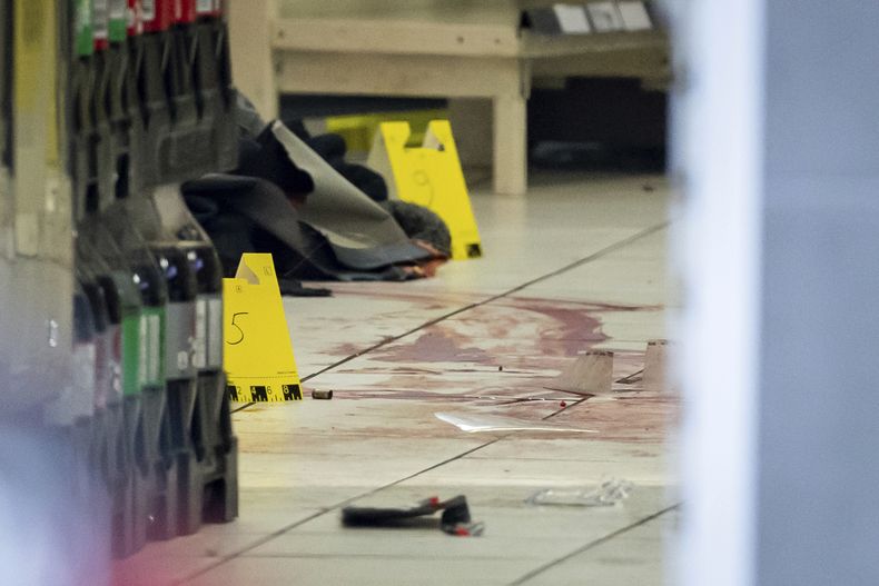 Marcadores de evidencia, restos y sangre en una escena del crimen dentro de una tienda 7-Eleven en Vancouver, Canadá, el miércoles 4 de diciembre de 2024. (Ethan Cairns/The Canadian Press via AP)