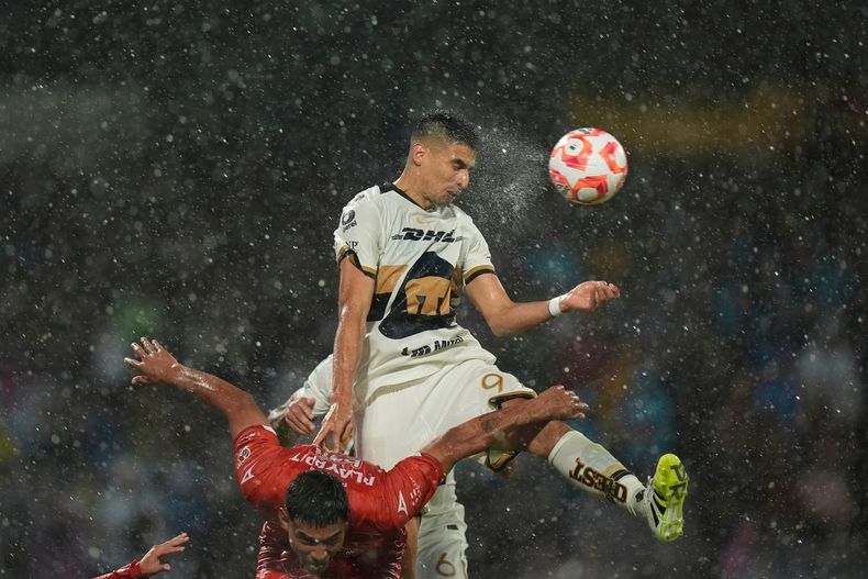Guillermo Martínez, de Pumas, remata detrás de Tomás Badaloni, de Necaxa, durante un partido de la Liga MX, disputado el domingo 10 de agosto de 2025 (AP Foto/Fernando Llano)