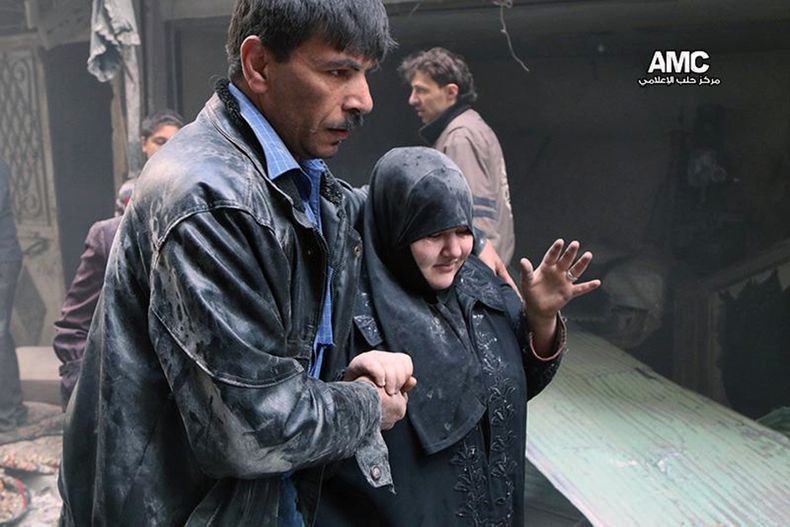 Fotograf&iacute;a del domingo 6 de abril de 2014 proporcionada por el grupo activista antigubernamental Aleppo Media Center (AMC), la cual fue autentificada por la AP, muestra a un hombre sirio ayudando a una sobreviviente de un edificio da&ntilde;ado por