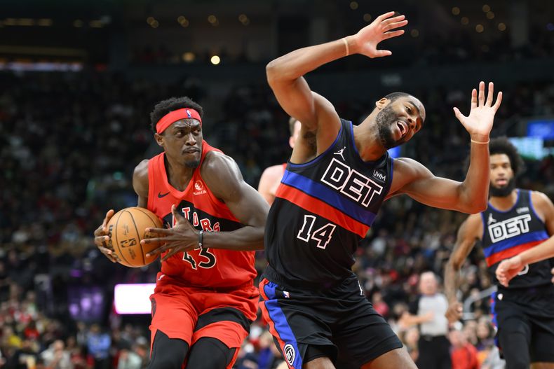 El alero de los Raptors de Toronto Pascal Siakam (43) recibe una falta del base de los Pistons de Detroit Alec Burks (14) mientras conduce hacia el aro durante la 2da mitad del juego en Toronto el 19 de noviembre de 2023. (Christopher Katsarov/The Canadian Press via AP)