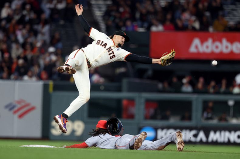 CJ Abrams, derecha, de los Nacionales de Washington, se roba la segunda base mientras Willy Adames, de los Gigantes de San Francisco, busca la pelota durante la novena entrada del juego de béisbol de Grandes Ligas, el lunes 8 de junio de 2026, en San Francisco. (AP Foto/Jed Jacobsohn)