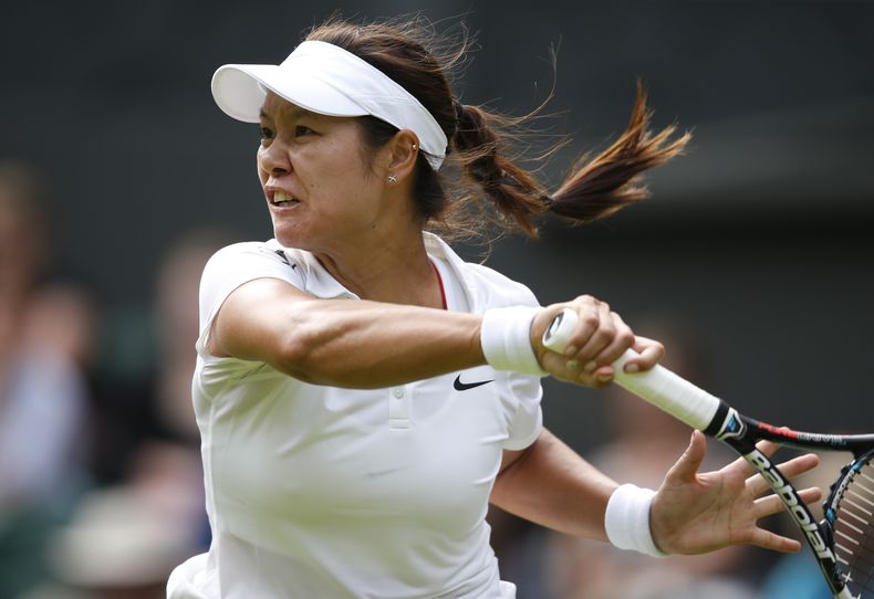 En esta foto del 23 de junio de 2014, la china Li Na hace una devoluci&oacute;n a la polaca Paula Kania en la priemra ronda de Wimbledon. El viernes 19 de septiembre, Li anunci&oacute; su retiro (AP Foto/Pavel Golovkin, archivo)