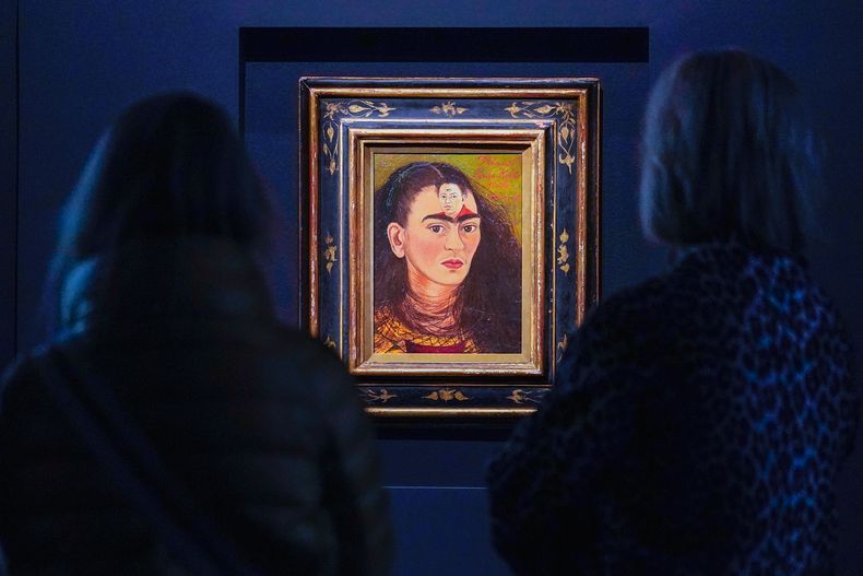 ARCHIVO - Los visitantes observan la pintura de Frida Kahlo titulada Diego y yo, expuesta en la casa de subastas Sothebys durante una presentación para la prensa en Nueva York, el 5 de noviembre de 2021. (Foto AP/Mary Altaffer, archivo)