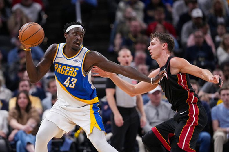 Pascal Siakam (43), de los Pacers de Indiana, empuja a Pelle Larsson (9), del Heart de Miami, durante la segunda mitad del juego de baloncesto de la NBA, el domingo 29 de marzo de 2026, en Indianápolis. (AP Foto/Michael Conroy)