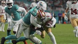 El receptor abierto de los 49ers de San Francisco, Deebo Samuel Sr. (1), es tacleado por el safety de los Dolphins de Miami, Jordan Poyer (21), justo antes de la zona de anotación durante la segunda mitad de un partido de fútbol americano de la NFL, el domingo 22 de diciembre de 2024, en Miami Gardens, Florida (AP Foto/Lynne Sladky)
