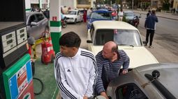 Personas repostan en una gasolinera mientras otros esperan detrás en una larga fila en La Habana, Cuba, el viernes 30 de enero de 2026. (AP Foto/Ramón Espinosa)