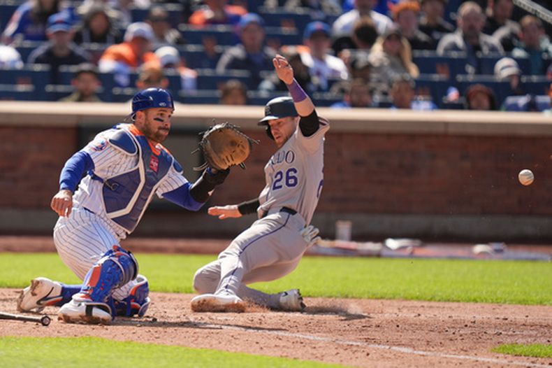 Brett Sullivan (26), de los Rockies de Colorado, a la derecha, se desliza a salvo hacia el plato mientras el receptor de los Mets de Nueva York, Luis Torrens, espera la pelota durante la séptima entrada del primer partido de béisbol de una doble cartelera, el domingo 26 de abril de 2026, en Nueva York. (AP Foto/Seth Wenig)