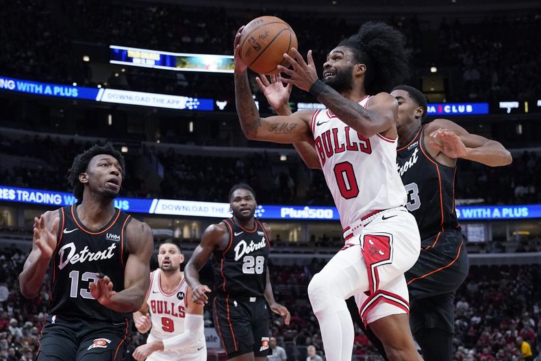 Coby White (0), de los Bulls de Chicago, se alista para encestar superando a Jaden Ivey y James Wiseman, izquierda, de los Pistons de Detroit, durante la primera mitad del juego de baloncesto de la NBA, en Chicago, el domingo 12 de noviembre de 2023. (AP Foto/Nam Y. Huh)