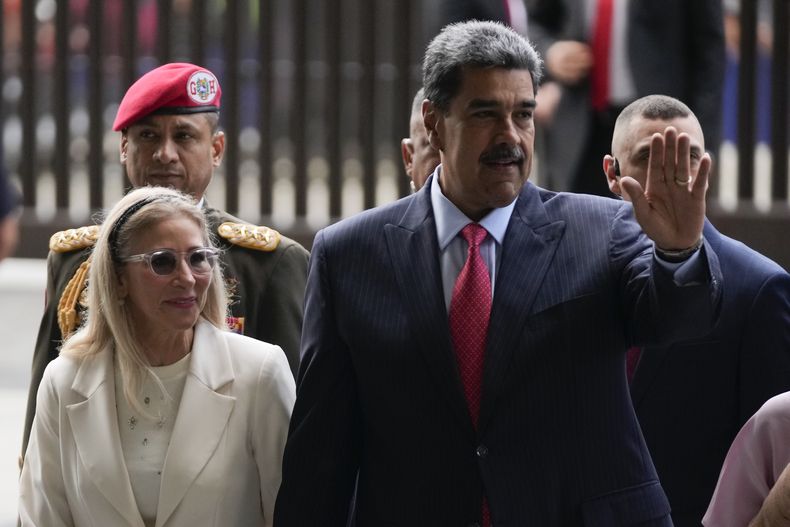 El presidente venezolano Nicolás Maduro saluda mientras él y su esposa Cilia Flores llegan a la Corte Suprema en Caracas, Venezuela, el miércoles 31 de julio de 2024, tres días después de su disputada reelección. (AP Foto/Fernando Vergara)