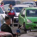 Un hombre con una chaqueta con los colores de la bandera de Venezuela hace fila para comprar combustible en una gasolinera, el viernes 6 de febrero de 2026, en La Habana, Cuba. (AP Foto/Ramón Espinosa)
