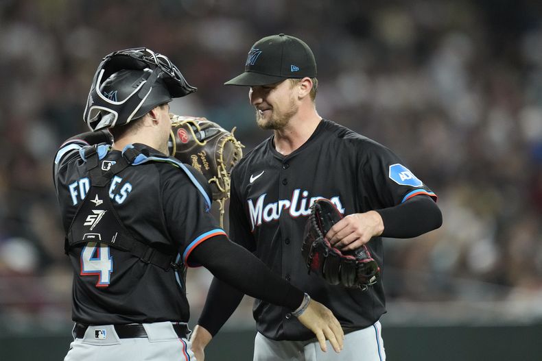 Braxton Garrett, derecha, abridor de los Marlins de Miami, celebra después de completar el partido con una blanqueada en contra de los Diamondbacks de Arizona, con el receptor Nick Fortes, izquierda, el viernes 24 de mayo de 2024, en Phoenix. (AP Foto/Ross D. Franklin)