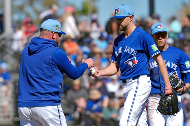 John Schneider (izquierda), mánager de los Azulejos de Toronto, releva al pitcher Jesse Hahn durante un juego de pretemporada contra los Yankees de Nueva York, el 24 de febrero de 2026, en Dunedin, Florida. (AP Foto/Chris OMeara)
