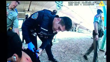 En esta imagen tomada del video de la cámara corporal de un agente del Departamento de Policía de Austin, mostrada en una conferencia de prensa el martes 22 de septiembre de 2026, los agentes revisan la herida de Wilber Rafael Garcés Pérez después de que un agente del Servicio de Inmigración y Control de Aduanas le disparara el domingo 20 de septiembre en Austin. (Departamento de Policía de Austin vía AP)