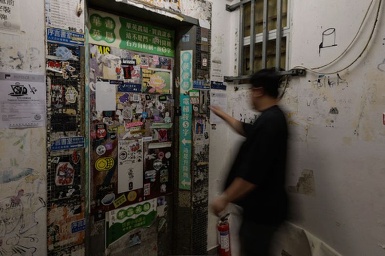 Una persona esperando al ascensor para acudir a varias tiendas, entre ellas Hong Kong Reader Bookstore, en Hong Kong, el 14 de agosto del 2026. (AP foto/May James)