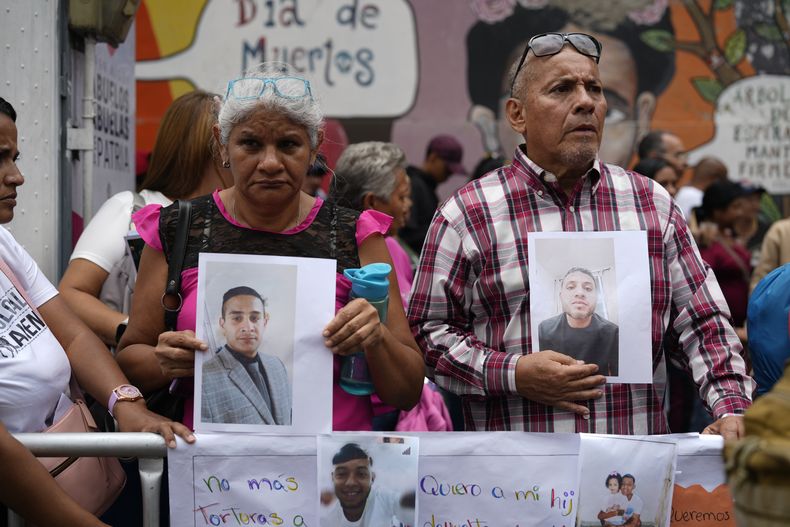 Varias personas que sostienen fotografías de parientes migrantes --de los que dicen fueron detenidos en Estados Unidos y aguardan a ser deportados-- participan en una manifestación organizada por el gobierno en Caracas, Venezuela, el martes 18 de marzo de 2025, para protestar por la deportación de presuntos miembros de la pandilla venezolana Tren de Aragua, que fueron transferidos a una cárcel en El Salvador. (AP Foto/Ariana Cubillos)