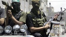 ARCHIVO - Combatientes palestinos de Hamas marchan en una camioneta con sus armas durante el funeral del extremista Emad Abu Kados, que murió durante enfrentamientos con hombres armados del movimiento Fatah en el vecindario Jeque Radwan, el 13 de junio de 2007, en la Ciudad de Gaza. (AP Foto/Hatem Moussa, archivo)